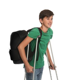 Photo of Teenage boy with injured leg using crutches on white background