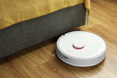 Photo of Robotic vacuum cleaner on wooden floor indoors