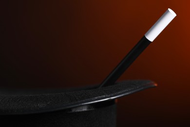 Photo of Magician's hat and wand on dark background, closeup