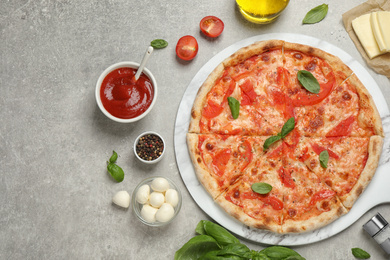 Photo of Delicious pizza Margherita and ingredients on light grey table, flat lay