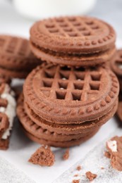 Photo of Tasty chocolate sandwich cookies with cream on light grey table, closeup
