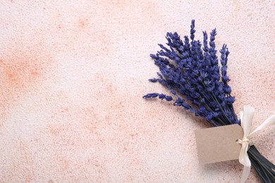 Photo of Bouquet of beautiful preserved lavender flowers with blank tag and ribbon on color textured table, top view. Space for text