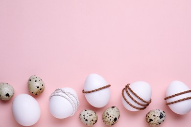 Photo of Beautifully decorated Easter eggs on pale pink background, flat lay. Space for text