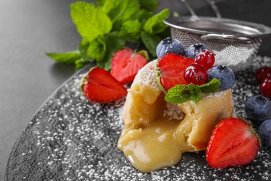Photo of Tasty vanilla fondant with white chocolate and berries on grey table, closeup. Space for text