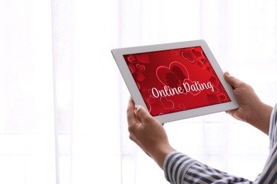Image of Woman visiting dating site via tablet indoors, closeup
