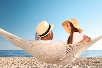 Photo of Happy couple relaxing in hammock on beach