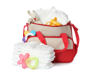 Photo of Maternity bag with disposable diapers and child's accessories on white background