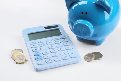 Photo of Calculator, piggy bank and coins on white background. Retirement concept