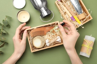 Photo of Woman with eco friendly bathroom products on green background, top view