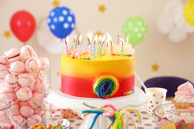 Photo of Table with birthday cake and delicious treats indoors