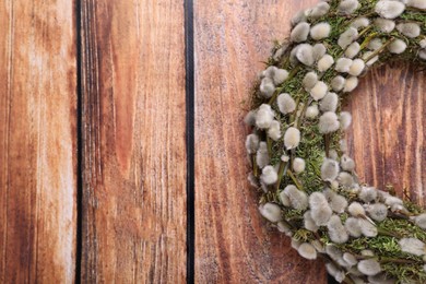 Photo of Wreath made of beautiful willow flowers on wooden table, top view. Space for text