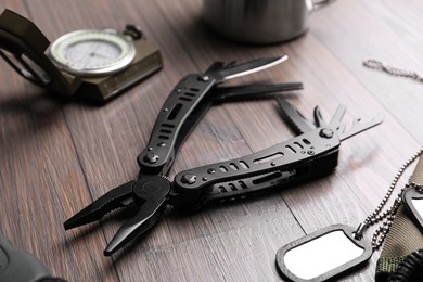 Photo of Modern compact portable multitool and accessories on wooden table