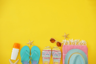 Photo of Flat lay composition with summer beach accessories on yellow background. Space for text