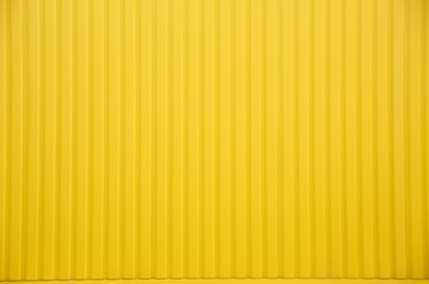 Photo of Bright yellow fence as background, closeup view