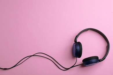 Photo of Stylish headphones on color background, top view. Space for text