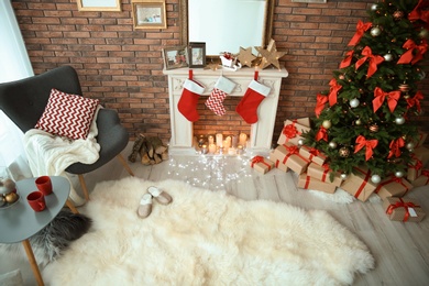 Photo of Room interior with beautiful Christmas tree and gifts near decorative fireplace