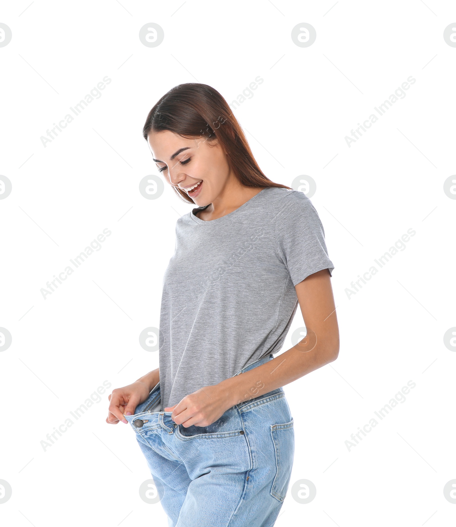 Photo of Slim woman in oversized jeans on white background. Weight loss