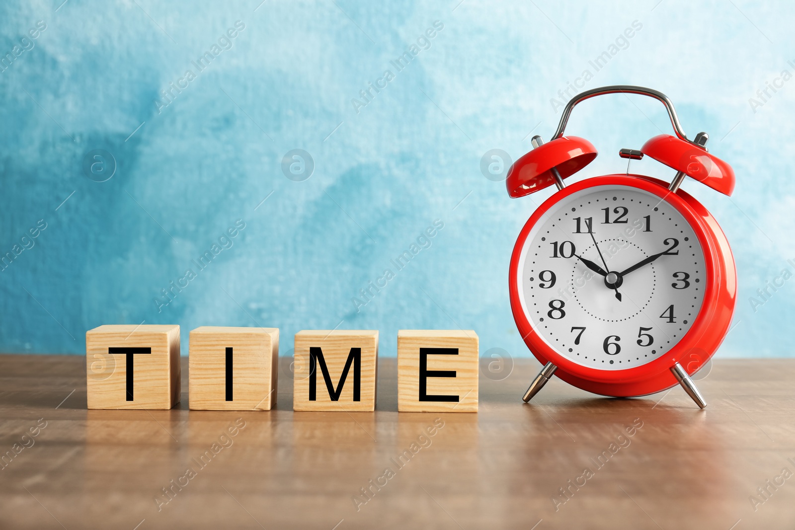 Photo of Cubes with text TIME and alarm clock on wooden table