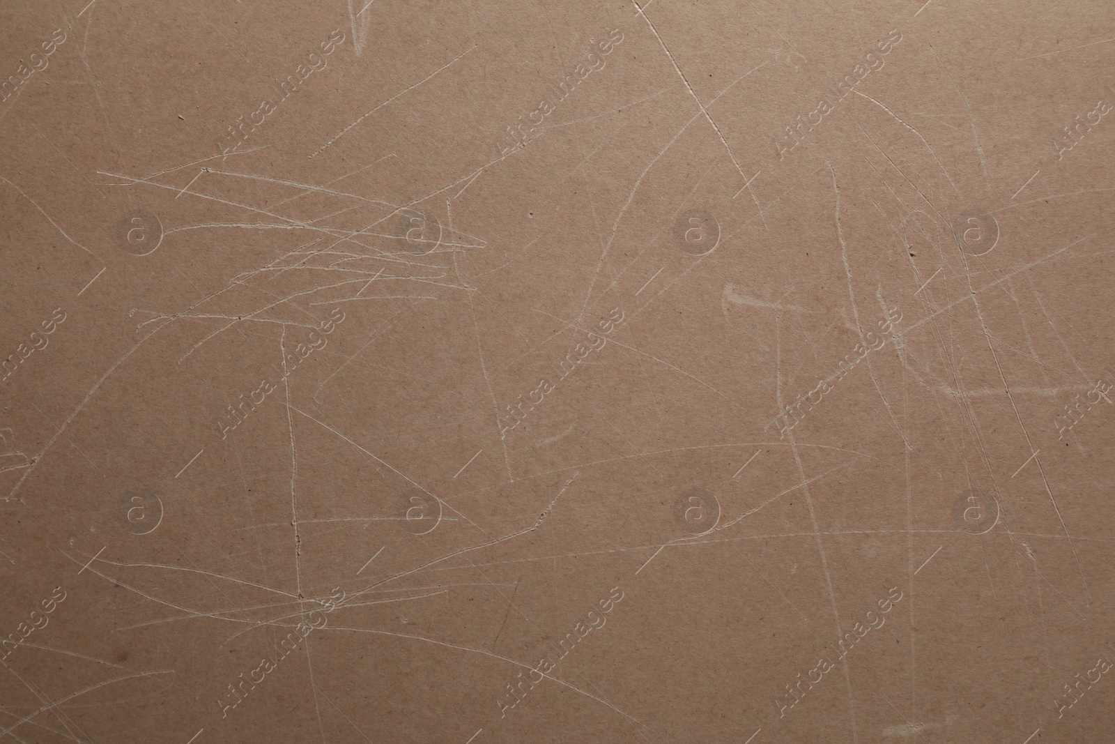 Photo of Old fiberboard with scratches as background, closeup