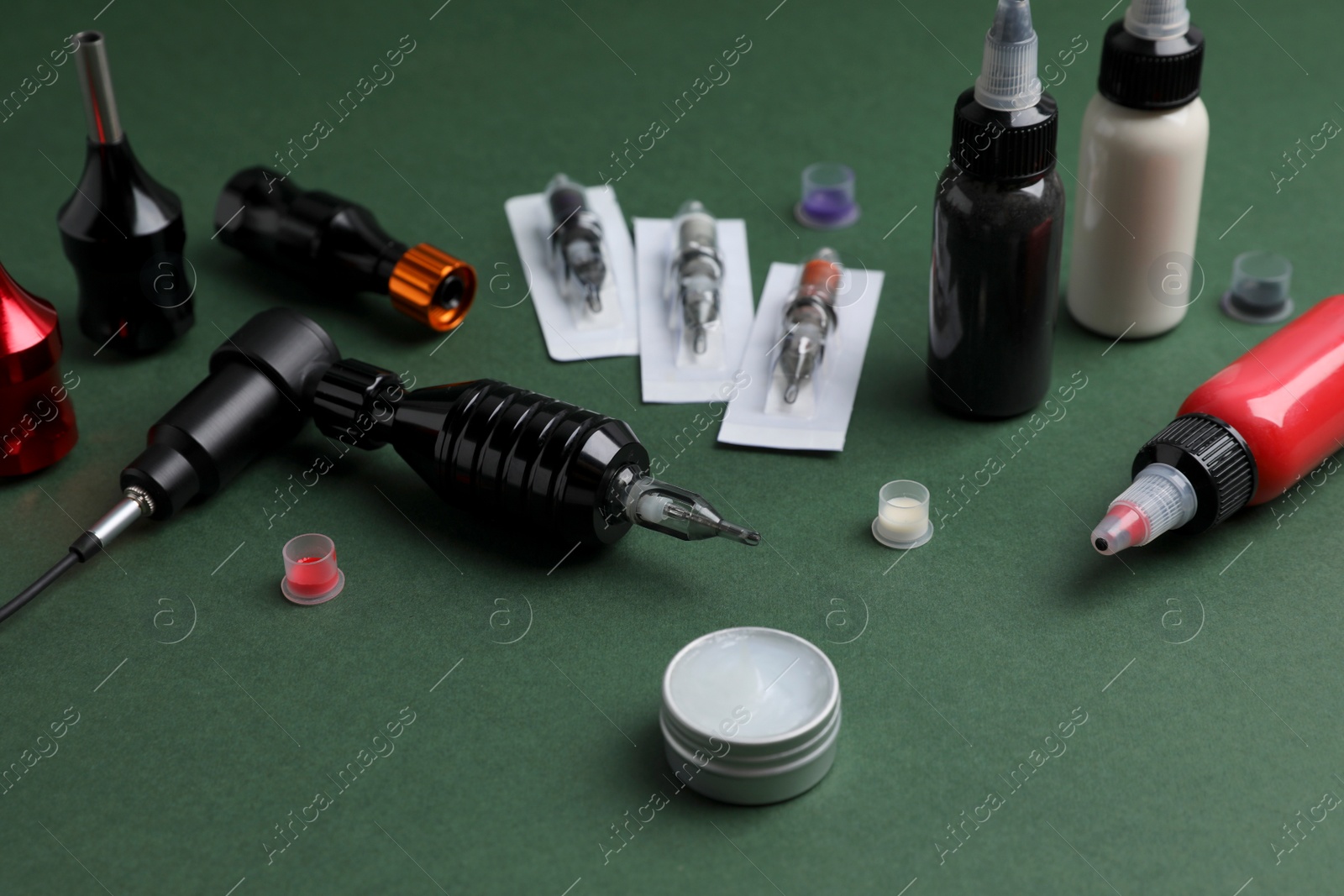 Photo of Professional tattoo equipment on dark green background
