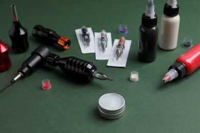 Professional tattoo equipment on dark green background