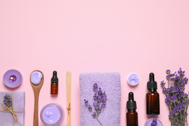 Photo of Cosmetic products and lavender flowers on pink background, flat lay. Space for text