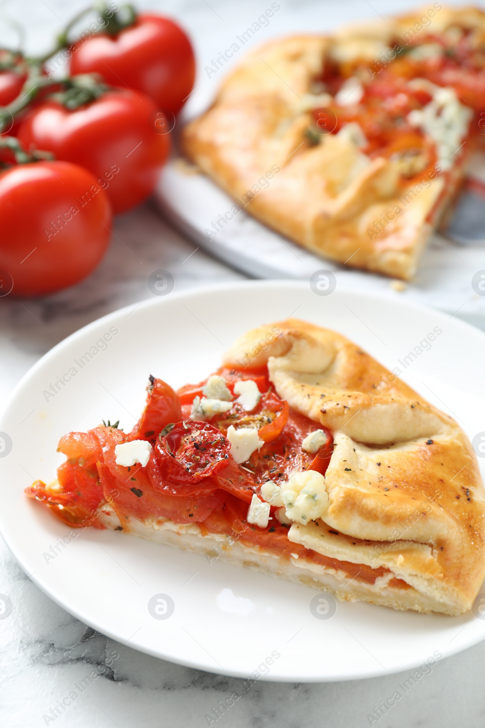 Photo of Tasty galette with tomato and cheese (Caprese galette) on white marble table, closeup