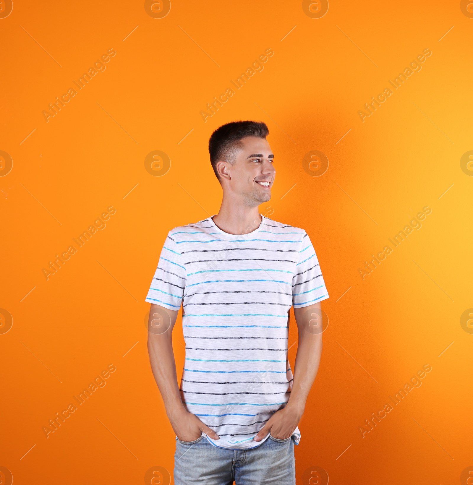 Photo of Handsome young man smiling on color background