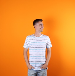 Handsome young man smiling on color background