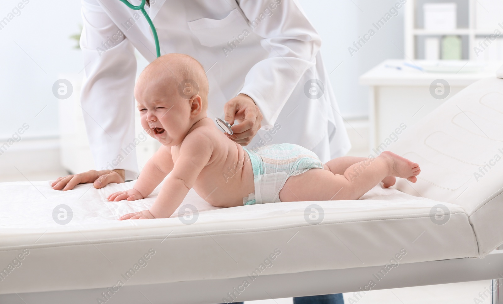 Photo of Children's doctor examining baby with stethoscope in hospital