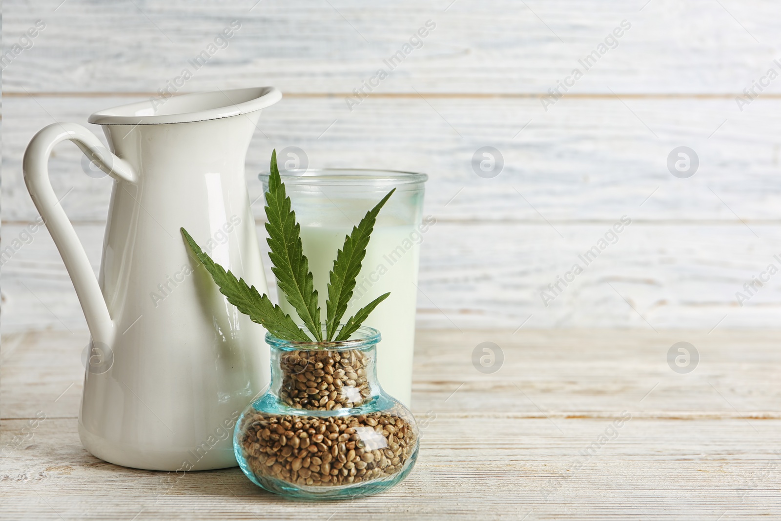 Photo of Composition with hemp seeds, milk and space for text on wooden background