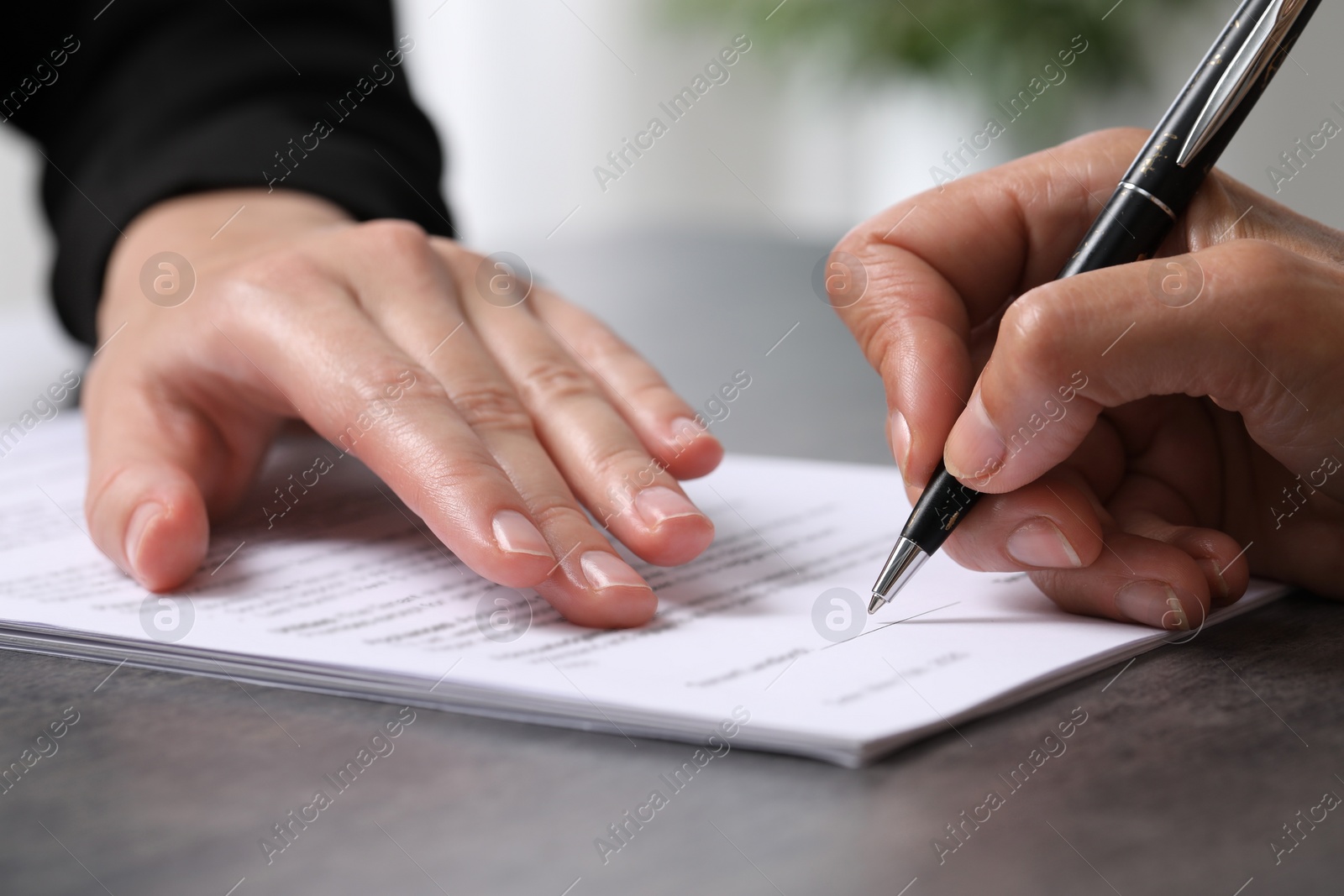 Photo of Manager showing client where she must to mark signature at dark table indoors, closeup