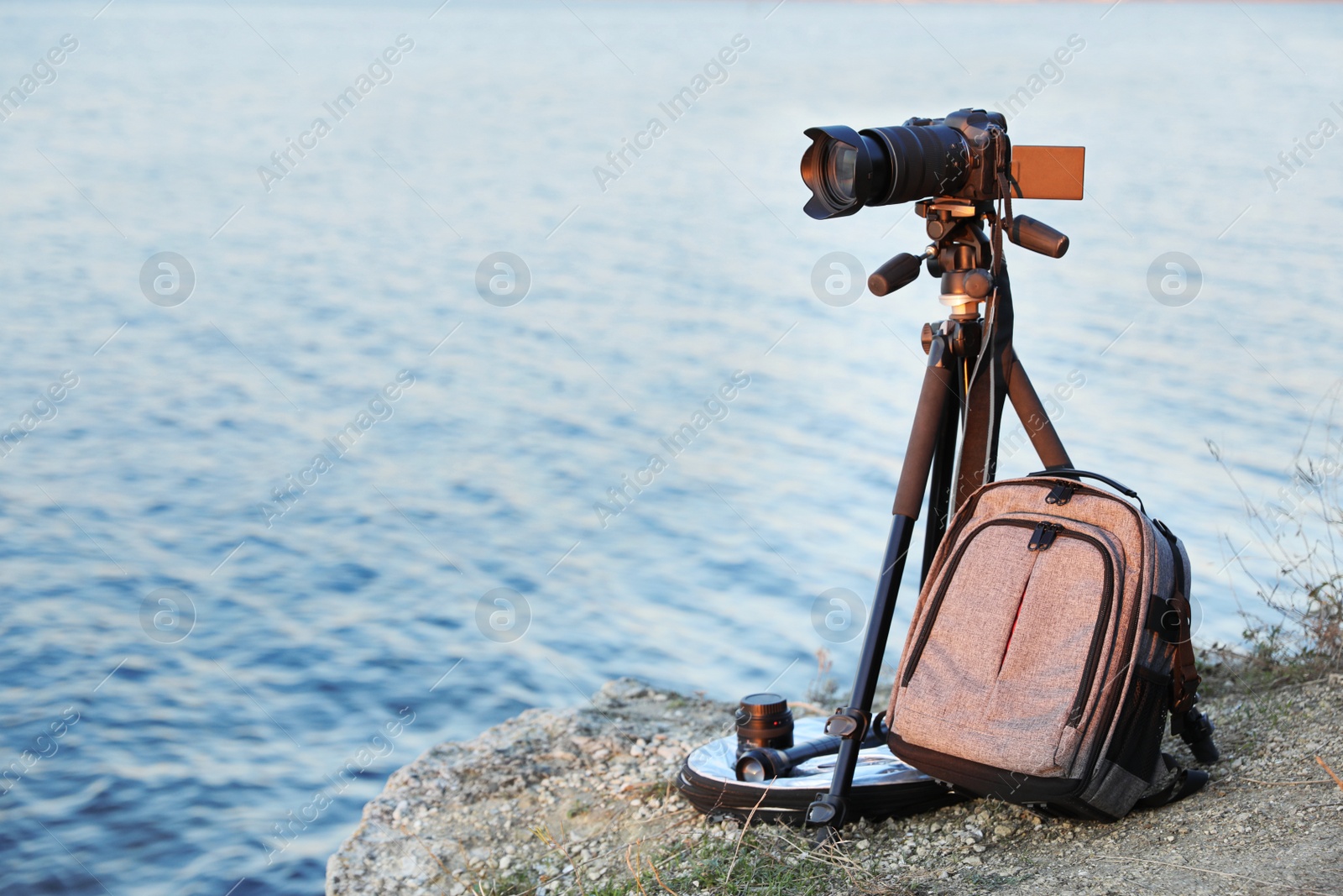 Photo of Professional photography equipment on rocky river coast