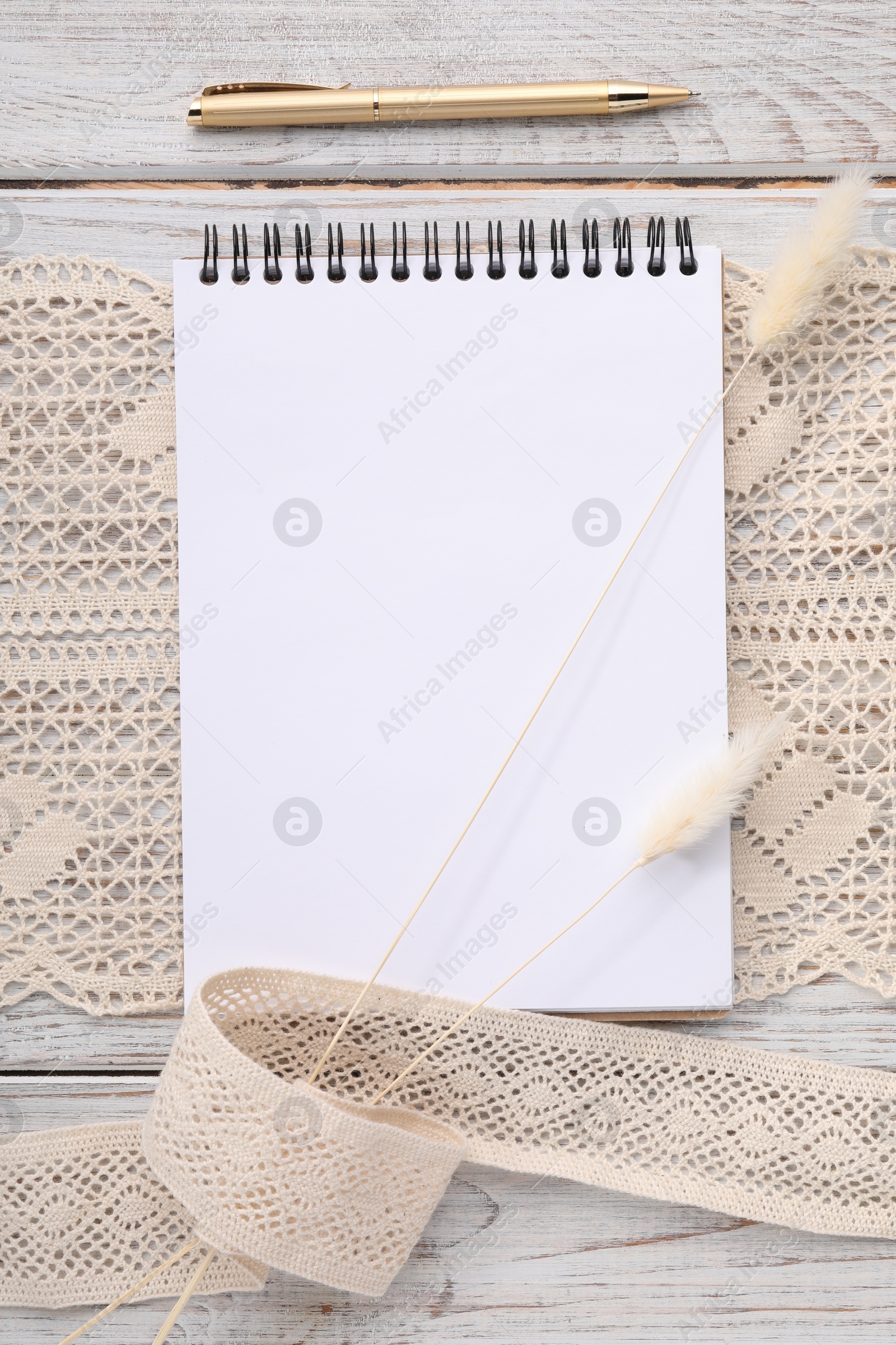 Photo of Guest list. Notebook, pen, spikelets and lace ribbons on wooden background, flat lay