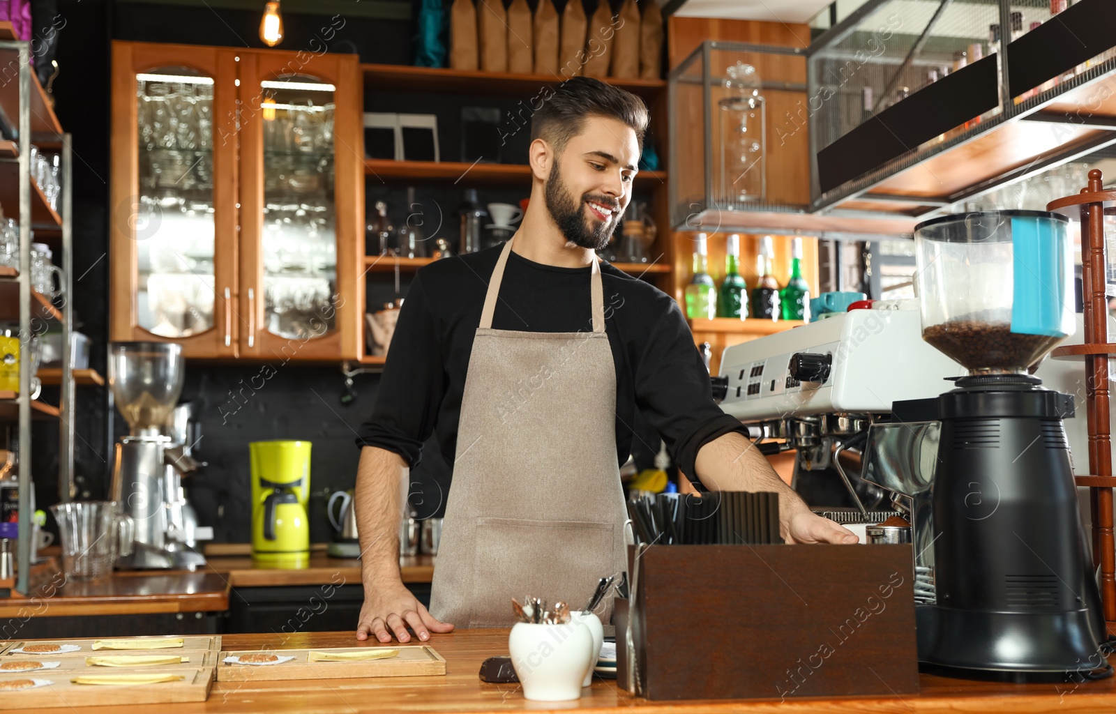 Photo of Barista pouring milled coffee from grinding machine into portafilter in cafe