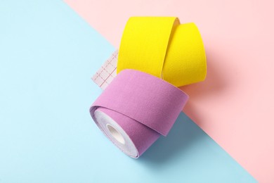 Photo of Bright kinesio tape in rolls on color background