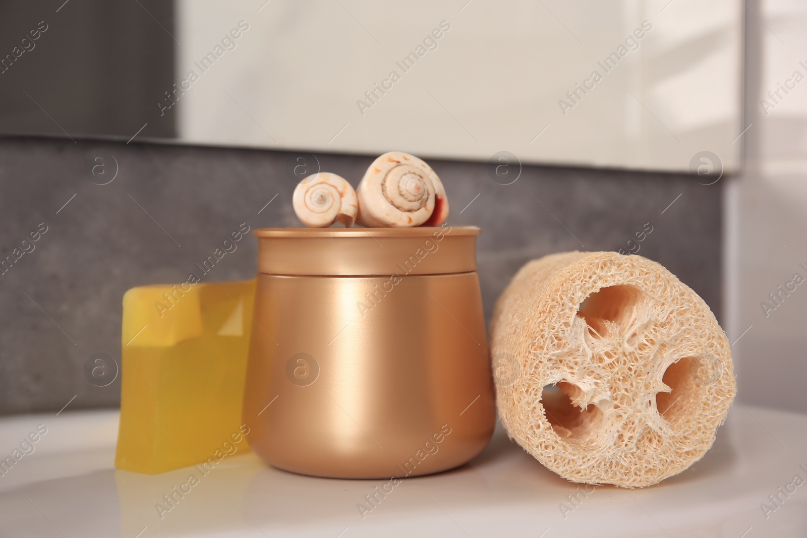 Photo of Loofah sponge and cosmetic products on sink in bathroom