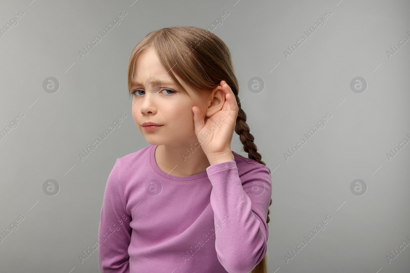 Photo of Little girl with hearing problem on grey background