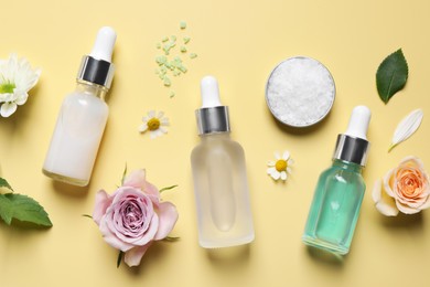 Photo of Flat lay composition with cosmetic serums on pale yellow background
