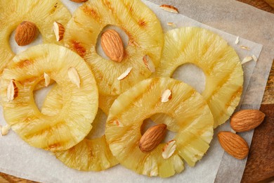 Photo of Tasty grilled pineapple slices and almonds on table flat lay