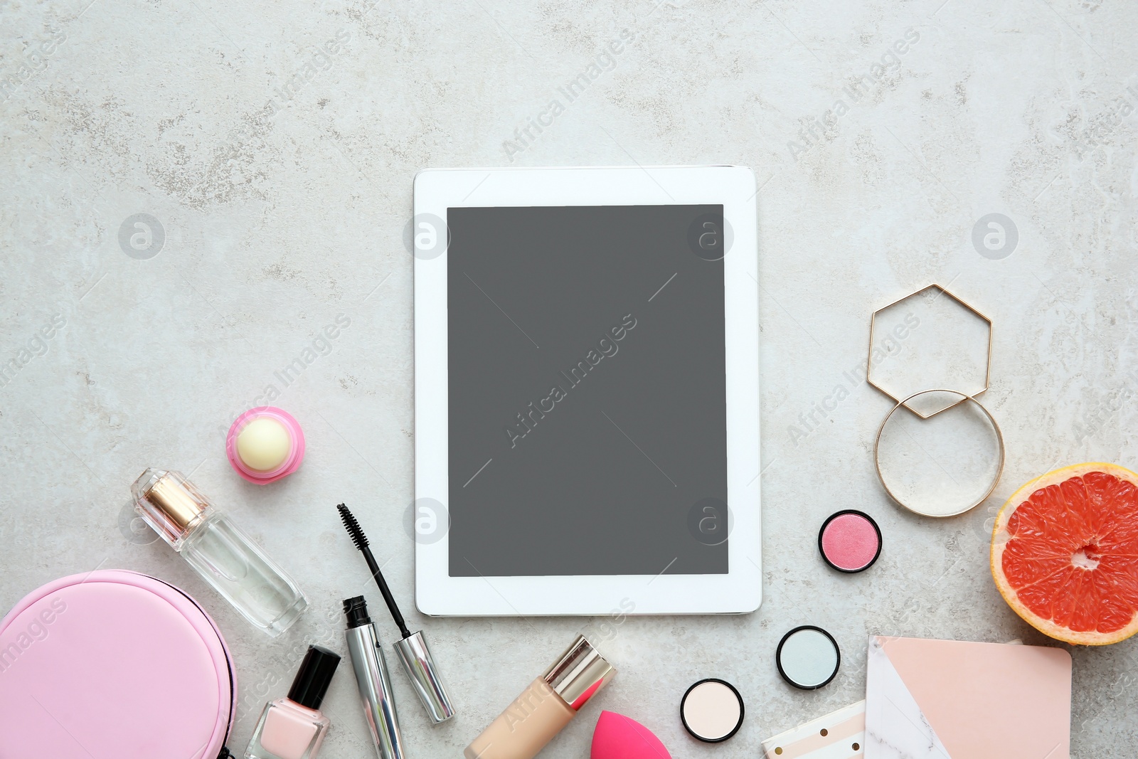 Photo of Flat lay composition with tablet and makeup products on grey background