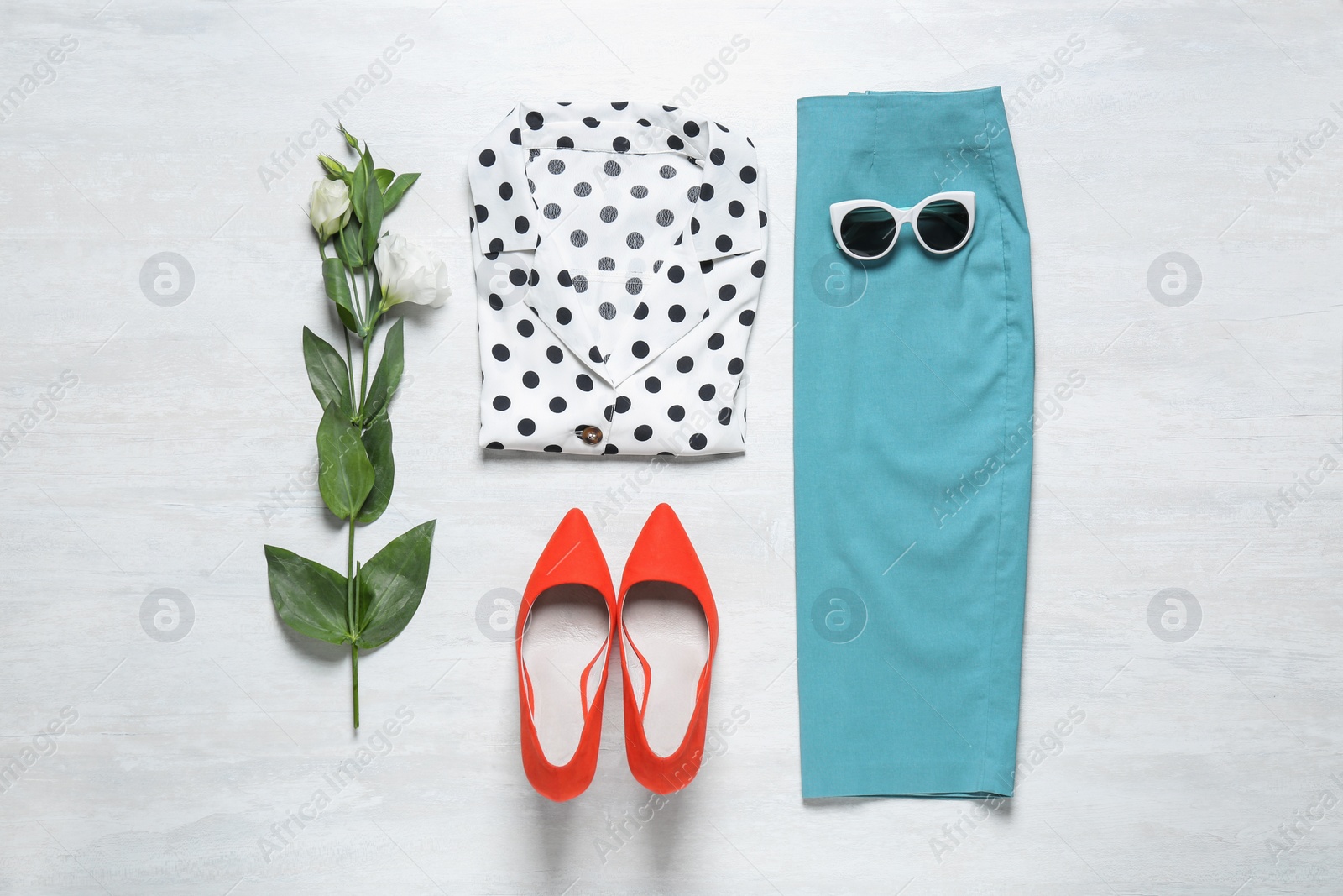 Photo of Stylish women's outfit on white wooden background, flat lay