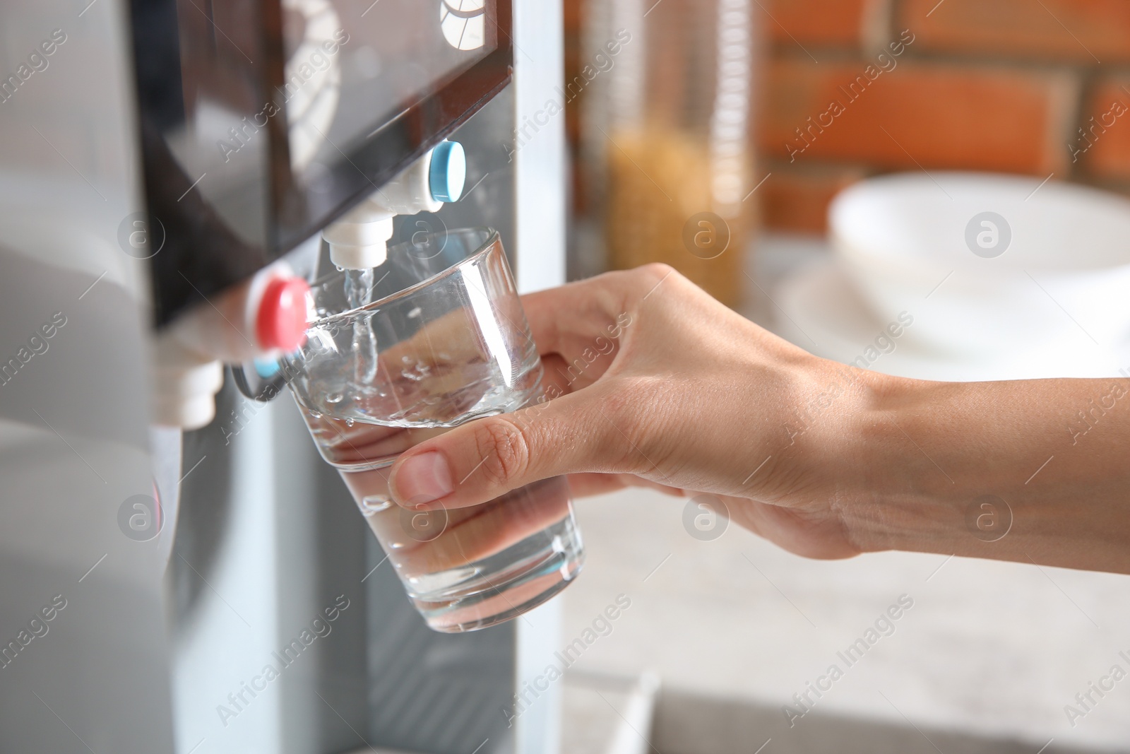 Photo of Woman filling glass with water from cooler indoors, closeup