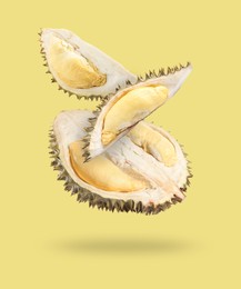 Image of Fresh ripe durians falling on pale yellow background