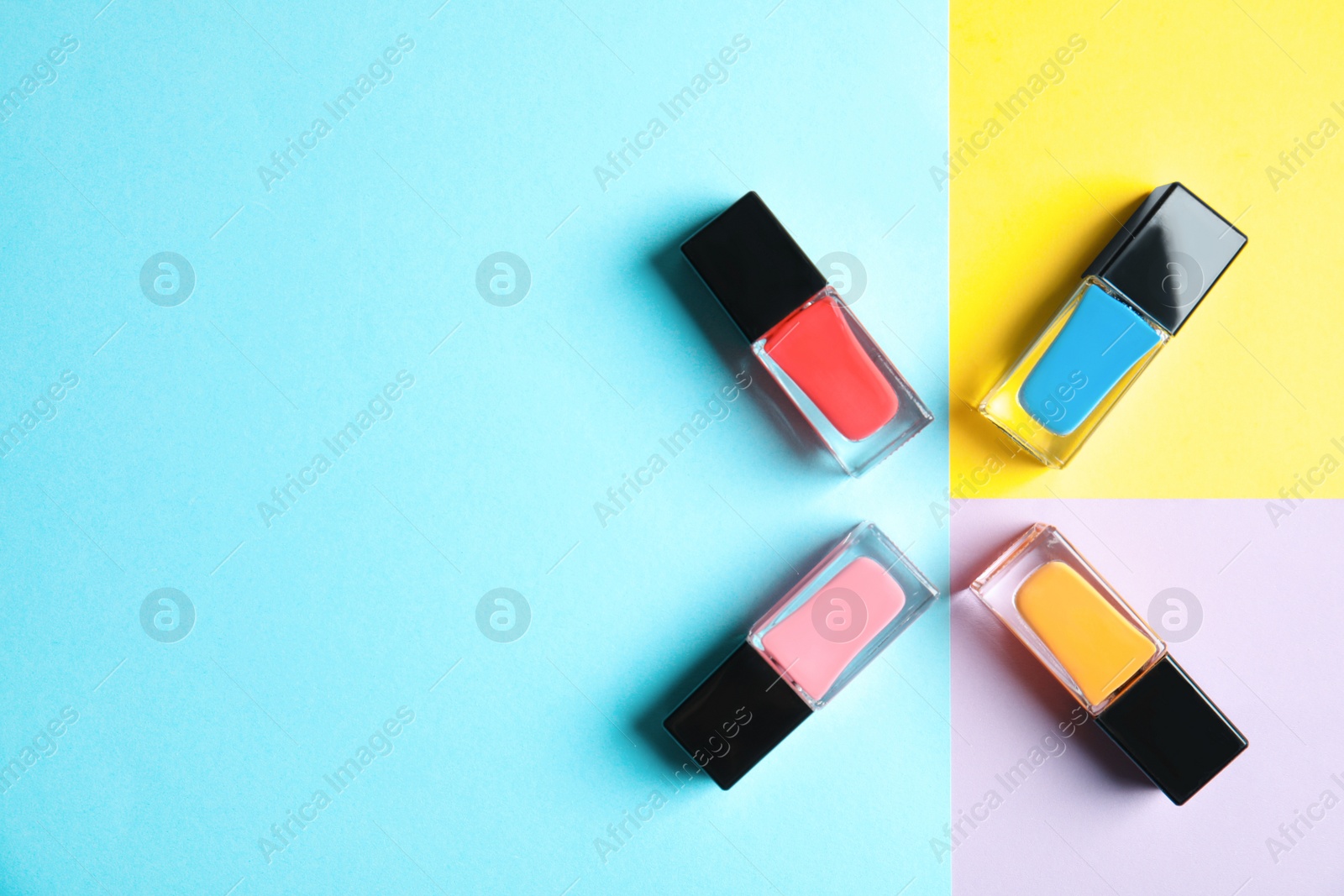 Photo of Bottles of nail polish on color background, top view with space for text