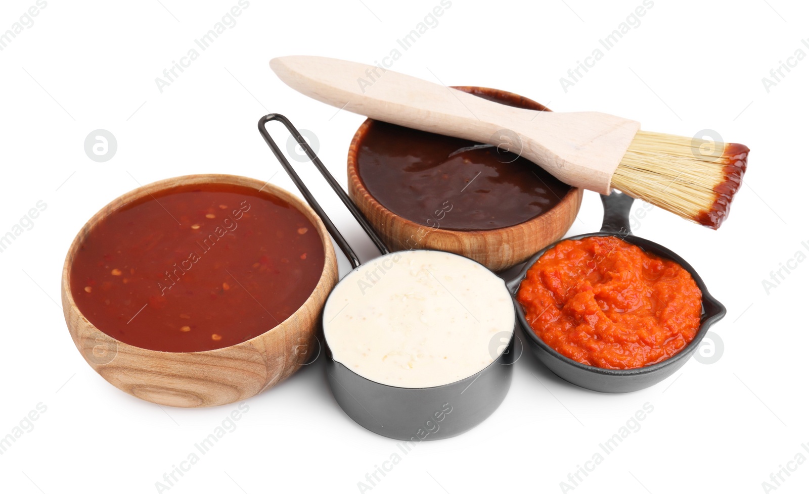 Photo of Different marinades and basting brush isolated on white