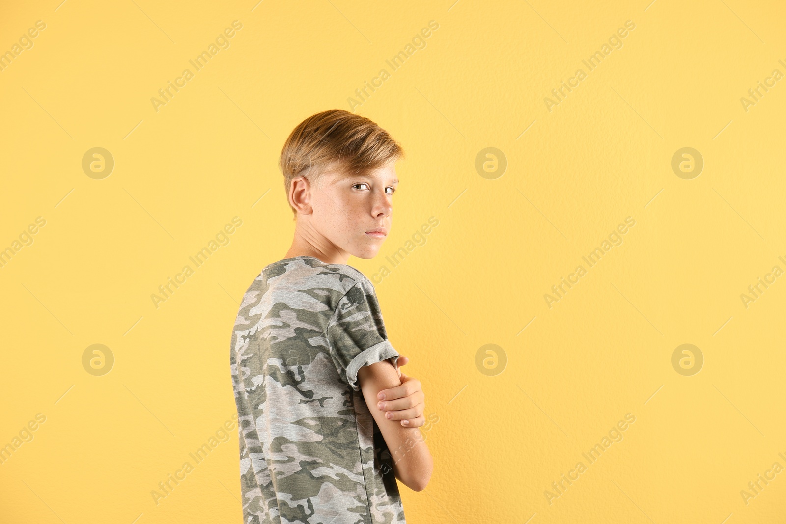 Photo of Portrait of young boy standing against color background