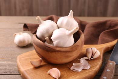 Photo of Fresh garlic and knife on wooden table, closeup