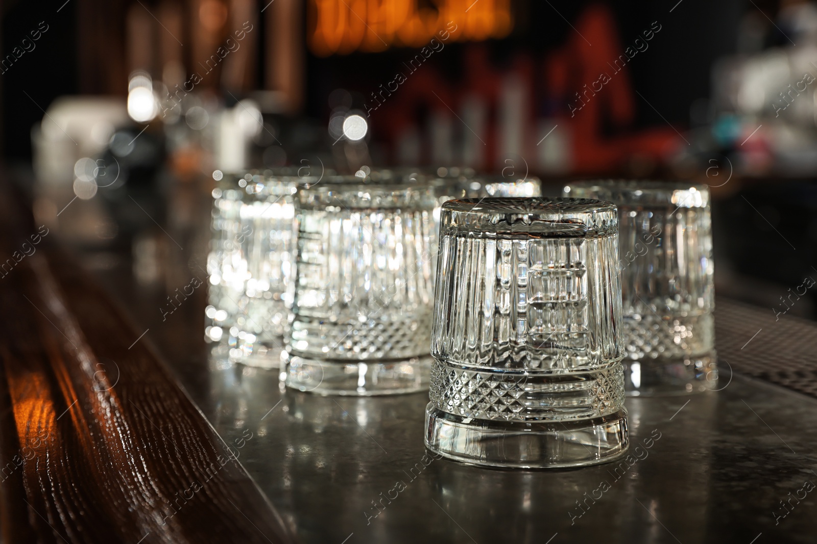 Photo of Empty clean glasses on counter in modern bar