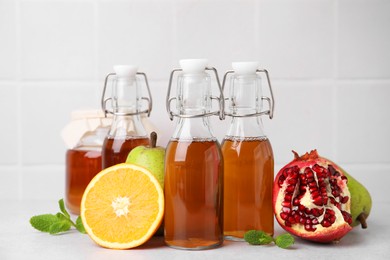 Photo of Tasty kombucha, fresh fruits and mint on white table